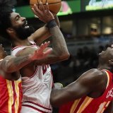 Coby White (au centre) va au contact avec Clint Capela (à droite). KEYSTONE/AP/Erin Hooley